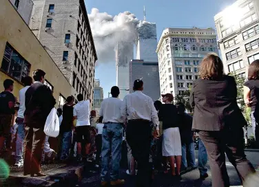  ??  ?? Pedestrian­s in lower Manhattan watch smoke billow from New York’s World Trade Center on Tuesday, Sept. 11, 2001. (AP Photo/Amy Sancetta)