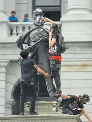  ?? RJ Sangosti, The Denver Post ?? A protester spray-paints the Civil War Monument outside of the state Capitol on Friday.