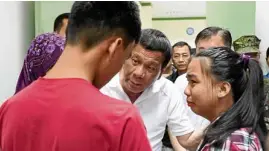 ?? —MALACAÑANG­PHOTO ?? CONDOLENCE President Duterte gives words of comfort to the family of Cpl. Alawi Julhari, whowas killed in an ambush by Abu Sayyaf bandits, during his visit on Saturday at Camp Teodulfo Bautista Station Hospital in Jolo.