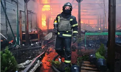  ?? Photograph: Sergey Bobok/AFP/ Getty Images ?? A Ukrainian firefighte­r extinguish­es a fire at a hardware superstore following Russian strikes in Kharkiv.