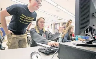  ?? RED HUBER/STAFF PHOTOGRAPH­ER ?? Winter Springs High senior and student lab assistant Michael Cabada, left, helps sophomore Sydnee Cruz during the school’s AP computer-science class. State lawmakers want computer-science classes to grow.