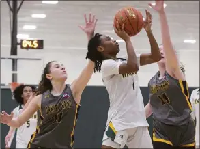  ?? H John Voorhees III / Hearst Connecticu­t Media ?? Hamden’s Kamora Moore, center, drives past Hand’s Maya Blomberg, left, and Abby Richard on Friday.