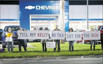  ?? Rebecca Droke/Post-Gazette ?? Members of the informal group Third District United protest the Republican-sponsored tax overhaul bill Thursday outside the car dealership owned by U.S. Rep. Mike Kelly along Route 8 in Butler.