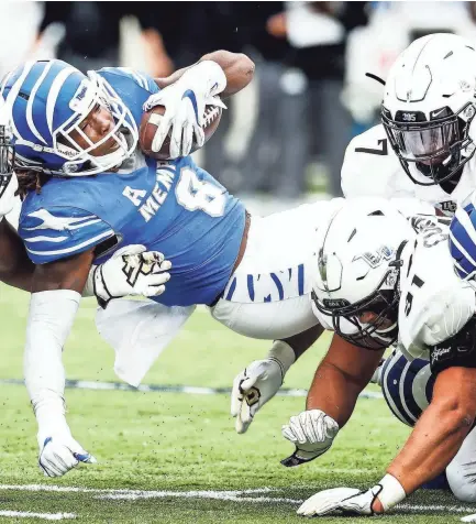  ?? MARK WEBER, THE COMMERCIAL APPEAL ?? Memphis running back Darrell Henderson is brought down by UCF on Saturday.