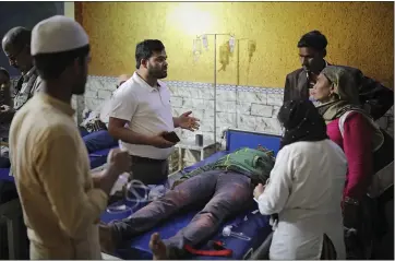  ?? PHOTOS BY ALTAF QADRI — THE ASSOCIATED PRESS ?? Dr. M.A. Anwar, left, speaks to family members of Mehdi Hassan, who was hit with an iron rod by rioters, as he is treated at Al-hind hospital in the Old Mustafabad neighborho­od of New Delhi.