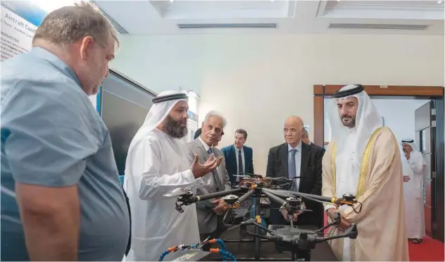  ?? ?? ↑ Sheikh Sultan Bin Ahmed is briefed on the technology involving the drones on display at the event.