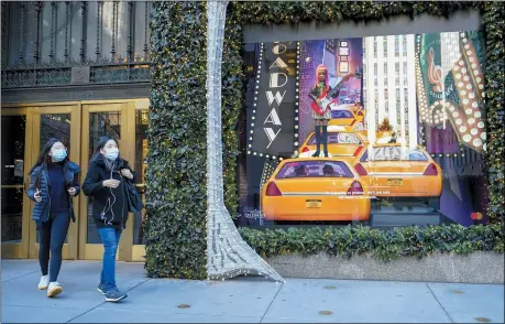  ?? THE ASSOCIATED PRESS ?? Black Friday shoppers wear face masks as the leave Saks Fifth Avenue flagships store empty handed, Nov. 27, in New York.