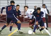  ??  ?? Granite Hills High School's Ivan Ayon, center, battles for the ball as Strathmore High School's defenders smother him Wednesday during the second half of overtime at Rankin Stadium in Portervill­e.