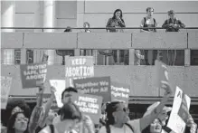  ?? Josie Norris/staff photograph­er ?? Students and onlookers watch as people march for reproducti­ve rights on campus at UTSA last month.