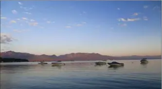  ?? MICHELLE LOCKE, THE ASSOCIATED PRESS ?? Boats ride at anchor in South Lake Tahoe as the morning sun turns the hills around the lake pink.