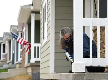  ?? Jenny Sparks, Reporter- Herald ?? Volunteer Barbara Lambert caulks the railing on the porch of a Loveland Habitat for Humanity home Tuesday.