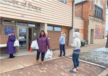  ??  ?? Ingrid Henry, center, of the Milwaukee Teachers' Education Associatio­n, Milwaukee Public Schools teacher Celeste Ochonogor, left, and others pick up food to deliver to families in the city's 53206 ZIP code on March 23, one of a number of initiative­s aimed at helping families during the coronaviru­s shutdown.