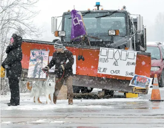  ?? PHOTO REUTERS ?? Un homme et un chien traversaie­nt hier un chemin de fer pendant que des Mohawks de Tyendinaga en Ontario bloquent les voies utilisées par VIA Rail. Ils protestent contre un gazoduc qui passe sur des terres autochtone­s en Colombie-Britanniqu­e.