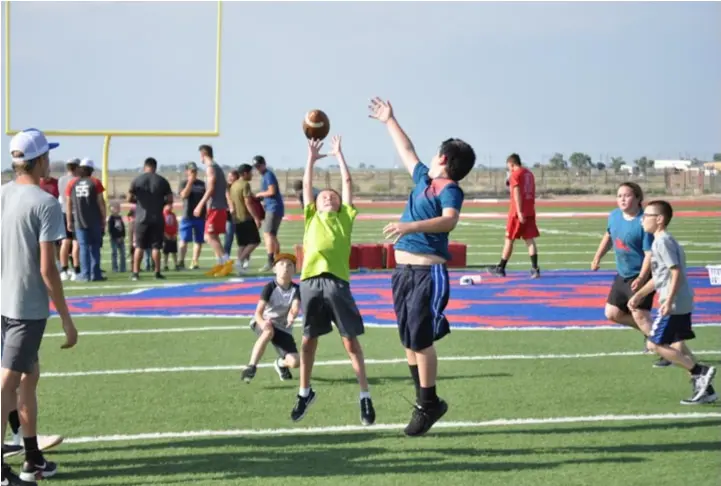  ??  ?? Noah Zamora, center, jumping for a pass past the reach of Joseph Montoya at the Estancia Bears youth football camp, Aug. 6. Photo by Ger Demarest.