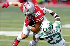  ?? Associated Press ?? No. 12 OREGON 35, No. 3 OHIO STATE 28. Oregon defensive back Verone McKinley, right, tackles Ohio State tight end Jeremy Ruckert during the second half Saturday in Columbus, Ohio.