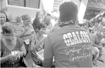  ?? CONTRIBUTE­D PHOTO ?? A staff of Councilor Rey Gealon distribute­s hot porridge to senior citizens in Barangay Sapangdaku, Cebu City during a feeding program.