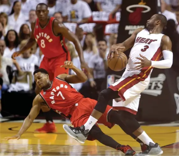  ?? ALAN DIAZ/THE ASSOCIATED PRESS ?? Miami’s Dwyane Wade collides with Toronto’s Kyle Lowry as the battle of the guards continues. Lowry and DeMar DeRozan combined to score 59 points for the Raptors on Friday night.