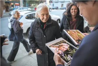  ?? Peter DaSilva / Special to The Chronicle ?? Anthropolo­gist Jane Goodall prepares to sign a photograph of herself for Marcu Siu before a special screening of “Jane” with director Brett Morgen at the Vogue Theatre in S.F.