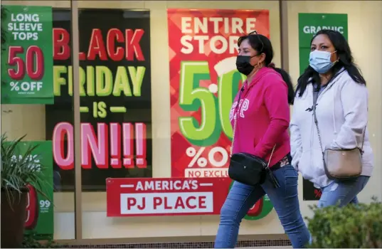  ?? ASSOCIATED PRESS FILE PHOTO ?? Black Friday shoppers wearing face masks shop at the Citadel Outlets in Commerce, Calif., Nov. 26, 2021.