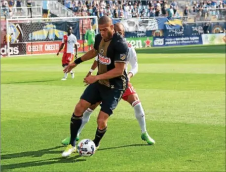  ?? MICHAEL REEVES — FOR DIGITAL FIRST MEDIA ?? Union defender Oguchi Onyewu holds off New England forward Teal Bunbury Sunday during the Union’s 3-0 win.