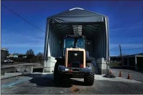  ?? (AP/Brynn Anderson) ?? A tractor sits Friday in front of a pile of salt at a state transporta­tion facility in Forest Park, Ga., as workers in the region prepare to treat roadways ahead of this weekend’s winter storm.