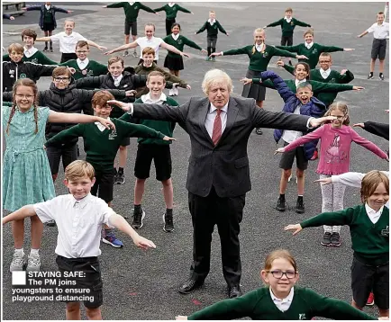  ??  ?? STAYING SAFE: The PM joins youngsters to ensure playground distancing