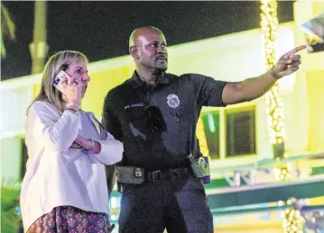  ?? D.A. VARELA dvarela@miamiheral­d.com ?? Miami Beach City Manager Alina Hudak stands with a police officer on Ocean Drive during spring break on March 15.