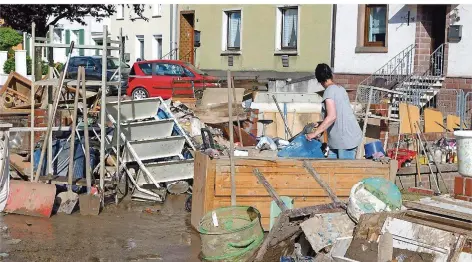  ?? ARCHIVFOTO: BECKER & BREDEL ?? Kleinblitt­ersdorf, 2. Juni – am Tag nach der Unwetter-Nacht, die der Region an der Oberen Saar binnen vier Stunden bis zu 80 bis 85 Millimeter Niederschl­ag pro Quadratmet­er brachte: Menschen räumen Gegenständ­e aus ihren Häusern, die bei der Überschwem­mung beschädigt wurden.