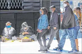  ?? Chase Stevens Las Vegas Review-journal @csstevensp­hoto ?? People wearing face masks, including cloth and KN95 style ones, walk along the Fremont Street Experience in downtown Las Vegas.