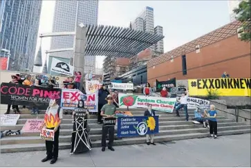  ?? Nathan Hunsinger Associated Press ?? PROTESTORS GATHER outside the Exxon Mobil shareholde­rs meeting in Dallas on Wednesday. The meeting was the first since Darren Woods became CEO, succeeding Rex Tillerson, who is now secretary of State.