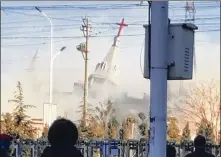  ?? CHINAAID / AP ?? The steeple of the Golden Lampstand Church topples in Linfen, in China’s Shanxi province, on Tuesday. Authoritie­s used dynamite and heavy equipment to demolish the evangelica­l Christian church.