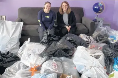  ?? RENEE COPELAND PHOTOS ?? Volunteer Jen Clancy, left, who came up with the idea for the shoe drive, and Christmas Without Cancer Vice President Renee Copeland show off some of the bags of shoes the charity has collected.“It feels good to know every single penny is going to help people and possibly even to people that we know,” Clancy said.