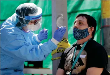  ?? ASSOCIATED PRESS FILE PHOTO ?? In this file photo, Tina Nguyen, left, a nurse at the Internatio­nal Community Health Services clinic in Seattle’s Internatio­nal District, takes a nose swab sample from David Carroll, an ICHS employee, during testing for the coronaviru­s in Seattle.