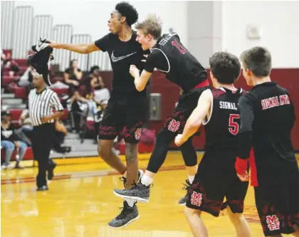  ?? STAFF PHOTO BY ERIN O. SMITH ?? Signal Mountain players celebrate a win in the District 6-AA boys’ basketball championsh­ip game over Tyner on Tuesday at Howard High School. The Signal Mountain boys’ and girls’ teams claimed District 6-AA tournament titles.