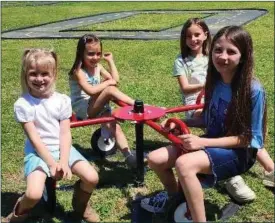  ?? Submitted Photo ?? In front, Emmily Brown and Serenity Swarts, and, in back, Elliot and Roreigh Beam sit on equipment at a new playground in Panama, which sits across from Willie Darneal Field and George Ollie Stadium.