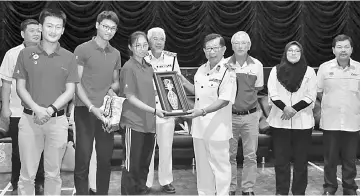 ??  ?? Dr Chan (fourth right) presents a memento to a representa­tive of the China team.