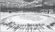  ?? CP PHOTO ?? Flowers lie at centre ice as people gather for a vigil at the Elgar Petersen Arena, home of the Humboldt Broncos, to honour the victims of a fatal bus accident in Humboldt, Sask.