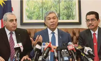  ?? PIC BY AHMAD IRHAM MOHD NOOR ?? Deputy Prime Minister Datuk Seri Dr Ahmad Zahid Hamidi at a press conference at Putra Perdana yesterday. With him are Palestinia­n Ambassador to Malaysia Datuk Dr Anwar H. Al Agha (left) and Home Ministry Deputy Secretary-General (operations) Datuk Wan...