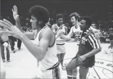  ?? RAY STUBBLEBIN­E — THE ASSOCIATED PRESS FILE ?? Kentucky’s Larry Johnson, left, lifts his arms in happiness as teammates James Lee, center, Mike Phillips (55) and Dwane Casey, congratula­te each other following Kentucky’s victory over North Carolina-charlotte, March 21, 1976, in the NIT in New York’s Madison Square Garden. Kentucky snatched the NIT championsh­ip, downing North Carolina-charlotte 71-67. New NCAA changes to the NIT selection process this year were designed to preserve the viability of the once-storied event in the face of possible competitio­n, but there has been criticism from coaches.