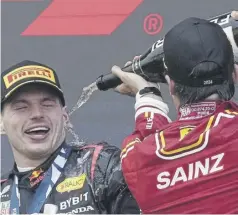  ?? ?? Carlos Sainz sprays champagne over winner Max Verstappen