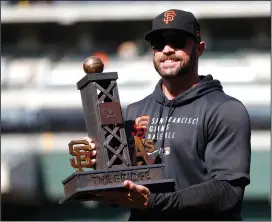  ?? NHAT V. MEYER/BAY AREA NEWS GROUP ?? Giants manager Gabe Kapler holds The Bridge Tom Pellack Memorial Trophy after the Giants 2-1 win over the Athletics to win the Bay Bridge Series in Oakland on Aug. 22, 2021.