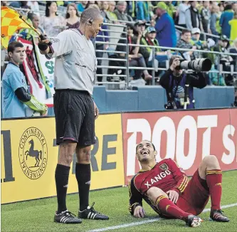  ?? STEPHEN BRASHEAR THE ASSOCIATED PRESS ?? Real Salt Lake's Fabian Espíndola, right, jokes with Referee's Assitant Joe Fletcher during the second half of play in a MLS soccer match, Saturday, May 12, 2012, in Seattle.