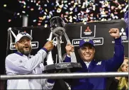  ?? DAVID BECKER / GETTY IMAGES ?? Coaches Jimmy Lake (left) and Chris Petersen of the Washington Huskies celebrate with the game trophy after defeating the Boise State Broncos 38-7 in the Las Vegas Bowl on Saturday.