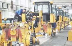  ??  ?? An employee works at an assembly line of bulldozers at a factory in Zhangjiako­u, Hebei province. China’s import and export growth accelerate­d in September, suggesting the world’s second-biggest economy is still expanding at a healthy pace despite...