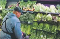  ?? AFP/Getty Images ?? A worker stocks shelves near romaine lettuce at a Washington, D.C., supermarke­t on Tuesday.