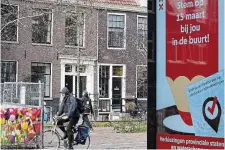  ?? PETER DEJONG THE ASSOCIATED PRESS ?? An electronic billboard calls on people to vote in Wednesday’s provincial election as a bicyclist passes in Amsterdam, Netherland­s.