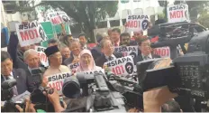  ?? — Reuters ?? Malaysian Opposition MPs hold up handwritte­n placards asking ‘Who is MO1?’ after staging a walkout in protest in parliament.