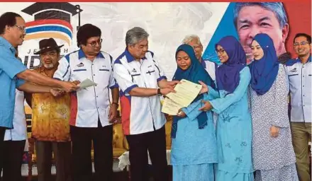  ?? BERNAMA PIC ?? Deputy Prime Minister Datuk Seri Dr Ahmad Zahid Hamidi handing over offer letters to students at the closing ceremony of the ‘Jelajah Pendidikan Bumiputera’ programme at SMK Hutan Melintang in Bagan Datuk yesterday.