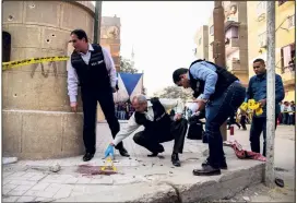  ?? (Photo AFP) ?? Des experts de la police égyptienne étaient au travail sur les lieux de l’attaque dans une église copte, près du Caire. Un djihadiste a été arrêté.