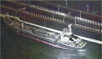  ?? — Reuters ?? A 2,591-tonne tanker, which is sent by strong wind crashes into a bridge connecting Kansai Airport, which is built on a manmade island in a bay, to the mainland, in Izumisano, western Japan, in this photo taken by Kyodo on Tuesday.